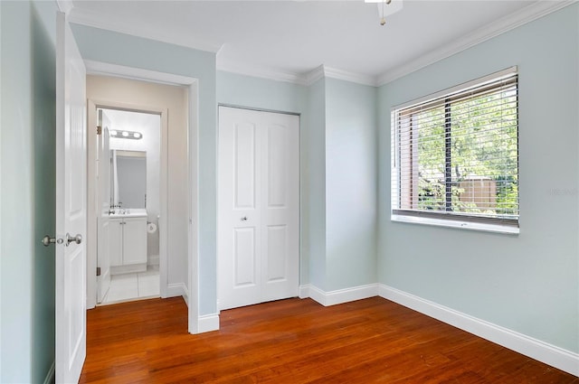 8 Oakmont Ct Unit 0, Palm Coast, FL 32137 - unfurnished bedroom with wood finished floors, baseboards, a closet, and crown molding