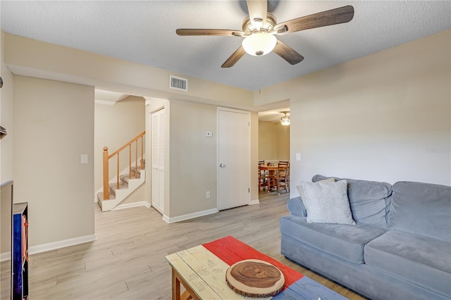 503 Kettering Way, Orange Park, FL 32073 - living area with a ceiling fan, stairs, light wood finished floors, baseboards, and a textured ceiling