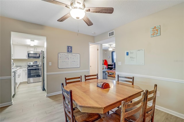 503 Kettering Way, Orange Park, FL 32073 - dining space with a ceiling fan, light wood-style floors, baseboards, and a textured ceiling