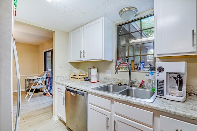 503 Kettering Way, Orange Park, FL 32073 - kitchen with stainless steel dishwasher, a sink, freestanding refrigerator, white cabinets, and light wood-type flooring