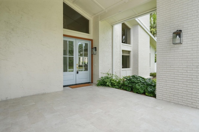 3 Cole Pl, Palm Coast, FL 32137 - view of exterior entry featuring french doors, a patio, stucco siding, and brick siding