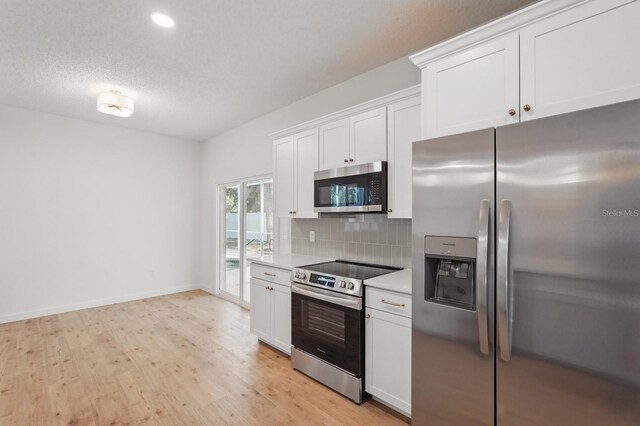 40 Pinetree Dr, Palm Coast, FL 32164 - kitchen featuring appliances with stainless steel finishes, backsplash, light countertops, light wood-type flooring, and white cabinets