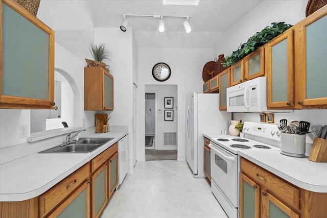 19 Utica Path, Palm Coast, FL 32164 - kitchen featuring white appliances, a sink, light countertops, glass insert cabinets, and a textured ceiling