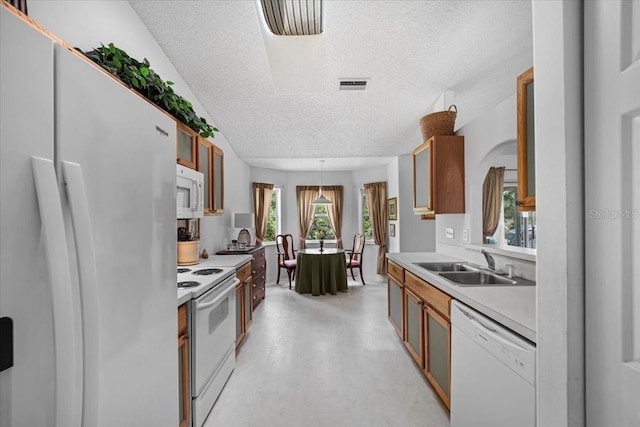 19 Utica Path, Palm Coast, FL 32164 - kitchen with white appliances, a textured ceiling, a sink, light countertops, and brown cabinetry