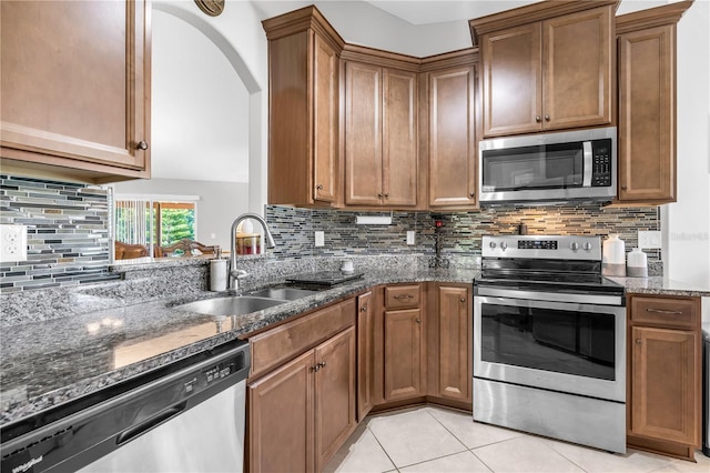 4 Contee Ct, Palm Coast, FL 32137 - kitchen with appliances with stainless steel finishes, a sink, dark stone countertops, tasteful backsplash, and brown cabinets
