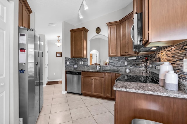 4 Contee Ct, Palm Coast, FL 32137 - kitchen featuring appliances with stainless steel finishes, backsplash, light tile patterned flooring, and brown cabinetry