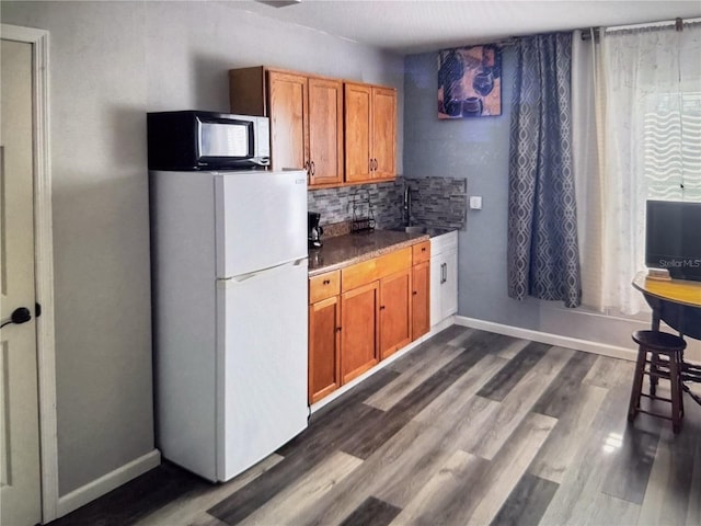 4 Contee Ct, Palm Coast, FL 32137 - kitchen with freestanding refrigerator, a sink, black microwave, and brown cabinets