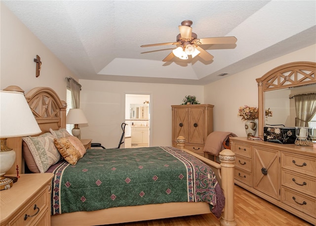 1 Butternut Dr, Palm Coast, FL 32137 - bedroom with a tray ceiling, light wood finished floors, a ceiling fan, multiple windows, and a textured ceiling