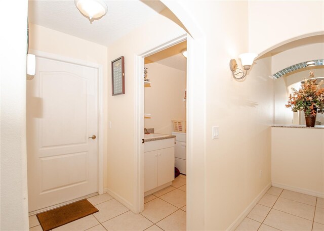 1 Butternut Dr, Palm Coast, FL 32137 - hall featuring light tile patterned floors, arched walkways, and baseboards