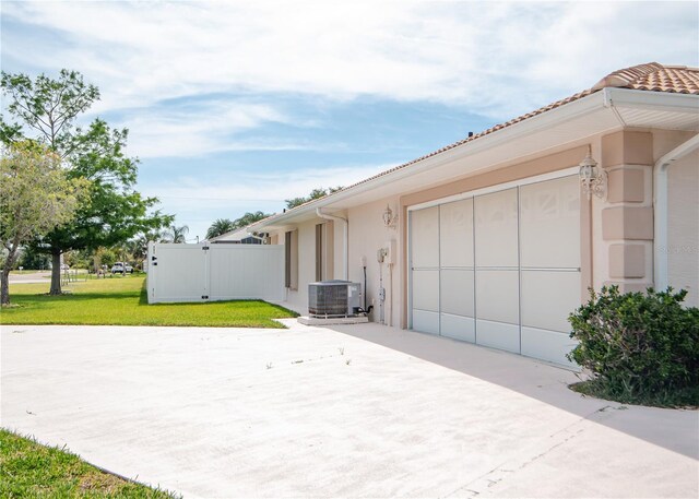 1 Butternut Dr, Palm Coast, FL 32137 - view of side of home featuring driveway, central AC, stucco siding, and a garage