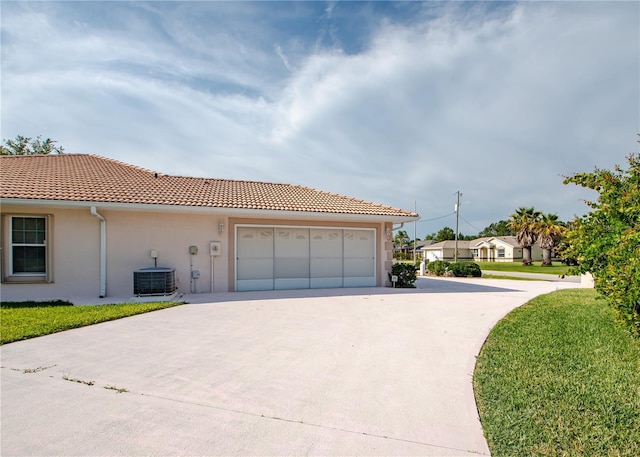 1 Butternut Dr, Palm Coast, FL 32137 - view of front facade with driveway, stucco siding, central AC, a garage, and a tile roof