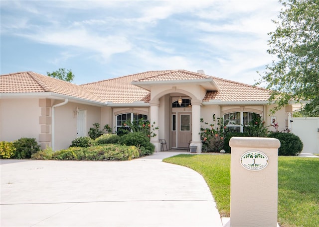 1 Butternut Dr, Palm Coast, FL 32137 - mediterranean / spanish-style house with a tiled roof, stucco siding, a front lawn, and concrete driveway