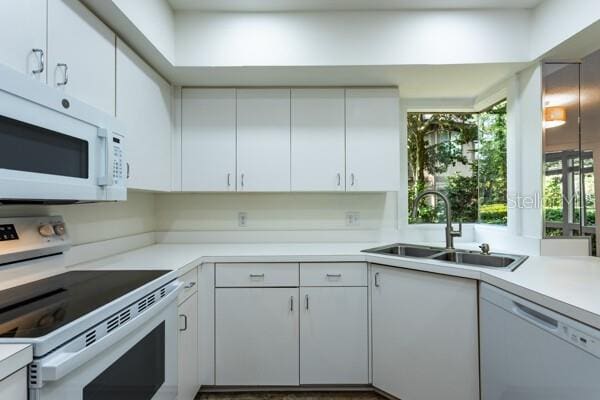 9 Masters Ct, Palm Coast, FL 32137 - kitchen with white appliances, a sink, light countertops, and white cabinetry