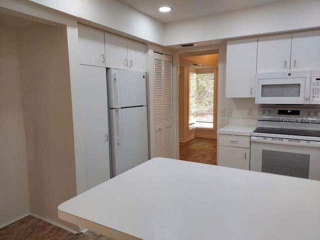 9 Masters Ct, Palm Coast, FL 32137 - kitchen with white appliances, light countertops, white cabinetry, recessed lighting, and baseboards