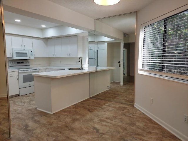 9 Masters Ct, Palm Coast, FL 32137 - kitchen featuring white appliances, a sink, light countertops, white cabinetry, and a peninsula