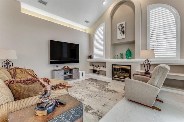 21 Webster Ln, Palm Coast, FL 32164 - living room with lofted ceiling, a glass covered fireplace, and built in shelves