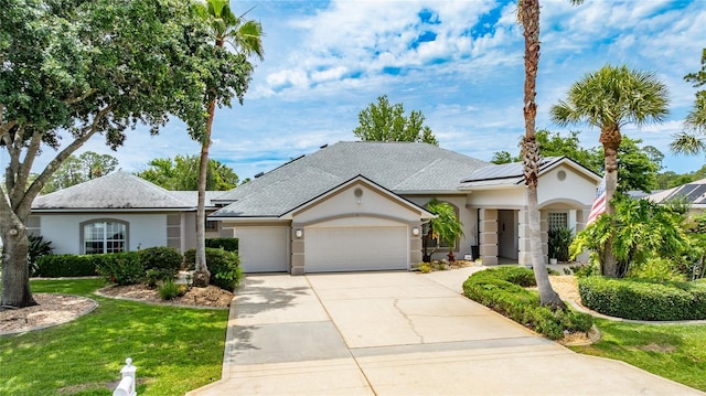 21 Webster Ln, Palm Coast, FL 32164 - view of front of house featuring a garage, stucco siding, driveway, and roof mounted solar panels