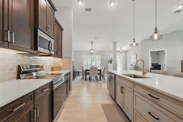 70 Esperanto Dr, Palm Coast, FL 32164 - kitchen featuring appliances with stainless steel finishes, a sink, decorative backsplash, light countertops, and dark brown cabinets