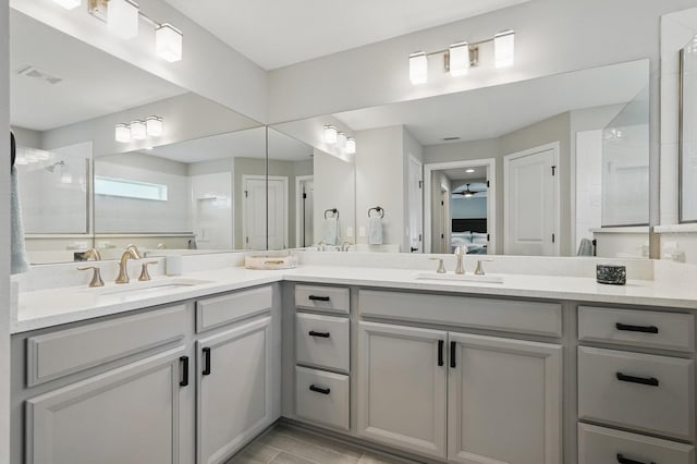 70 Esperanto Dr, Palm Coast, FL 32164 - ensuite bathroom with double vanity, a tile shower, a ceiling fan, and wood finished floors