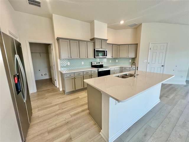 96 Waverly Ln, Palm Coast, FL 32164 - kitchen with appliances with stainless steel finishes, a sink, gray cabinets, light wood-style floors, and decorative backsplash