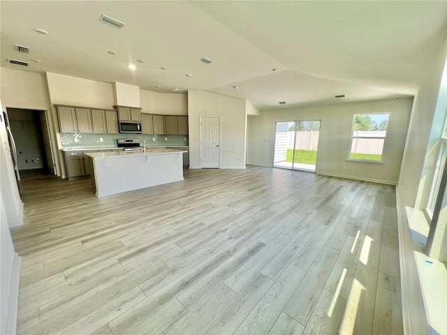 96 Waverly Ln, Palm Coast, FL 32164 - kitchen with appliances with stainless steel finishes, open floor plan, gray cabinets, light countertops, and vaulted ceiling