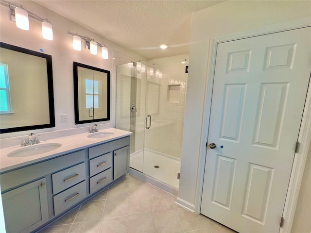 96 Waverly Ln, Palm Coast, FL 32164 - bathroom with tile patterned flooring, a textured ceiling, a stall shower, and double vanity