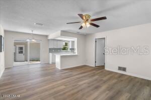 4901 Sailfish Dr, Ponce Inlet, FL 32127 - unfurnished living room featuring ceiling fan, wood finished floors, and baseboards