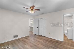 4901 Sailfish Dr, Ponce Inlet, FL 32127 - unfurnished bedroom with wood finished floors, baseboards, a closet, and ceiling fan
