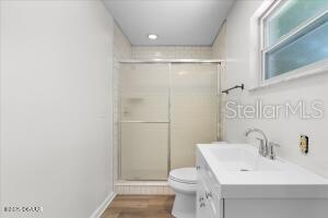 4901 Sailfish Dr, Ponce Inlet, FL 32127 - bathroom with toilet, a stall shower, vanity, and wood finished floors