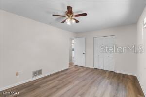 4901 Sailfish Dr, Ponce Inlet, FL 32127 - unfurnished bedroom with wood finished floors, baseboards, a closet, and a ceiling fan