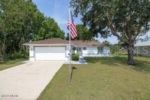 54 Price Ln, Palm Coast, FL 32164 - single story home featuring a garage, concrete driveway, and a front lawn