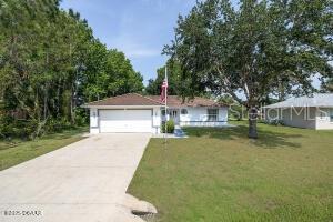 54 Price Ln, Palm Coast, FL 32164 - ranch-style house with concrete driveway, a garage, and a front lawn