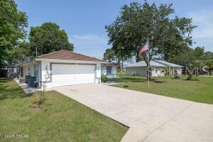 54 Price Ln, Palm Coast, FL 32164 - view of front of home with concrete driveway, a garage, and a front yard