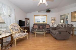 54 Price Ln, Palm Coast, FL 32164 - living area with vaulted ceiling, wood finished floors, and a ceiling fan