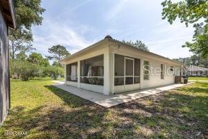 54 Price Ln, Palm Coast, FL 32164 - view of side of property with a sunroom and a yard