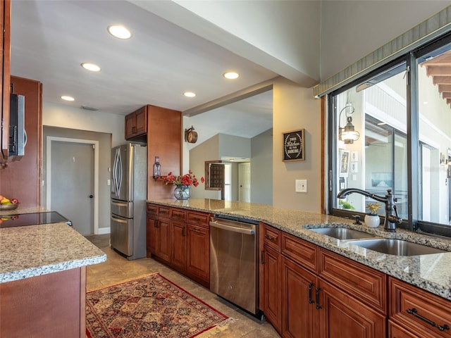 9 Cotton Ct, Palm Coast, FL 32137 - kitchen featuring stainless steel appliances, a sink, recessed lighting, light stone countertops, and brown cabinets