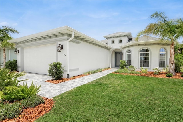 80 N Lakewalk Dr, Palm Coast, FL 32137 - mediterranean / spanish house featuring an attached garage, stucco siding, a front lawn, and driveway
