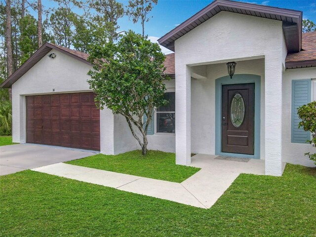 14 Zollinger Pl, Palm Coast, FL 32164 - view of front of house with stucco siding, a front yard, a garage, and concrete driveway