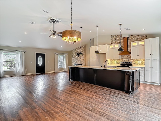 14 Zollinger Pl, Palm Coast, FL 32164 - kitchen featuring wall chimney range hood, stainless steel electric range, light countertops, open floor plan, and wood finished floors