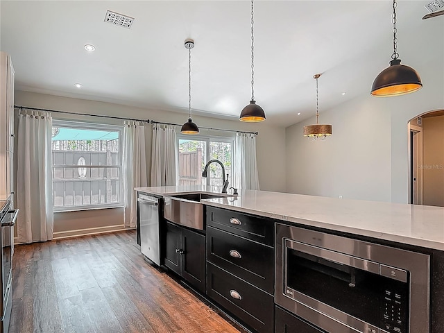 14 Zollinger Pl, Palm Coast, FL 32164 - kitchen featuring stainless steel appliances, dark cabinets, a sink, wood finished floors, and arched walkways