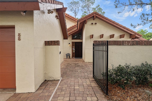 55 Village Cir, Palm Coast, FL 32164 - doorway to property featuring a gate and stucco siding