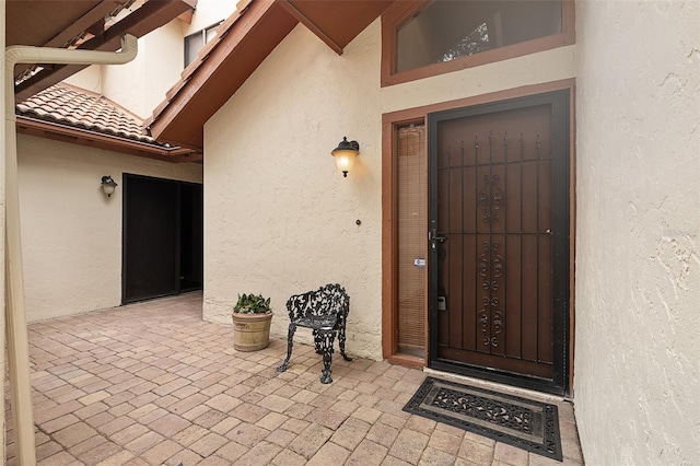 55 Village Cir, Palm Coast, FL 32164 - doorway to property featuring stucco siding and a patio