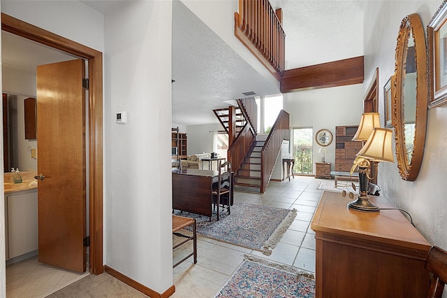 55 Village Cir, Palm Coast, FL 32164 - entrance foyer featuring stairs, a textured ceiling, baseboards, and light tile patterned floors