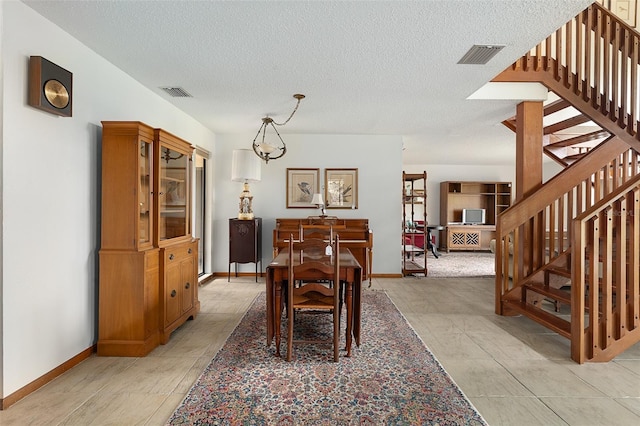 55 Village Cir, Palm Coast, FL 32164 - dining area with stairway, a textured ceiling, baseboards, and light tile patterned flooring
