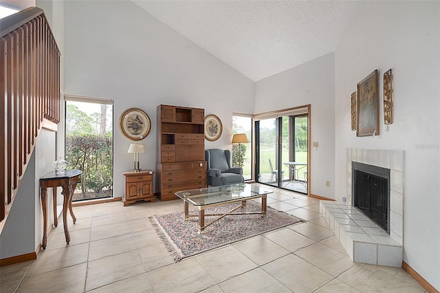 55 Village Cir, Palm Coast, FL 32164 - living room with high vaulted ceiling, healthy amount of natural light, a textured ceiling, a tile fireplace, and light tile patterned floors