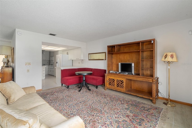 55 Village Cir, Palm Coast, FL 32164 - living room with light tile patterned floors, baseboards, and a textured ceiling