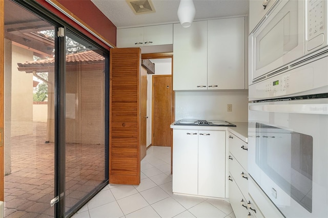 55 Village Cir, Palm Coast, FL 32164 - kitchen with white appliances, white cabinets, light countertops, and light tile patterned flooring