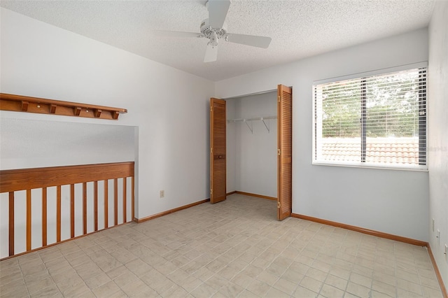 55 Village Cir, Palm Coast, FL 32164 - unfurnished bedroom with a closet, a textured ceiling, baseboards, and a ceiling fan