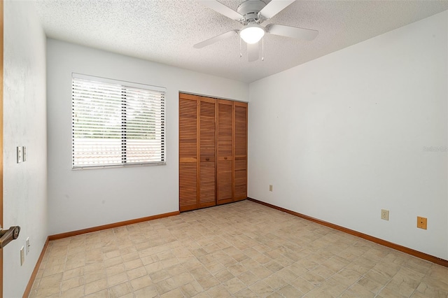 55 Village Cir, Palm Coast, FL 32164 - unfurnished bedroom featuring a textured ceiling, a closet, baseboards, and ceiling fan