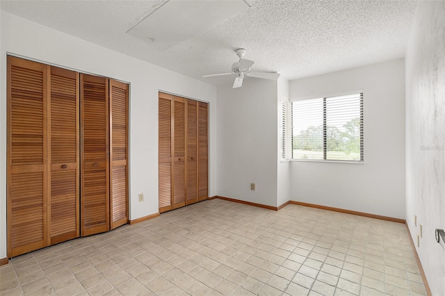 55 Village Cir, Palm Coast, FL 32164 - unfurnished bedroom with multiple closets, a textured ceiling, baseboards, and ceiling fan